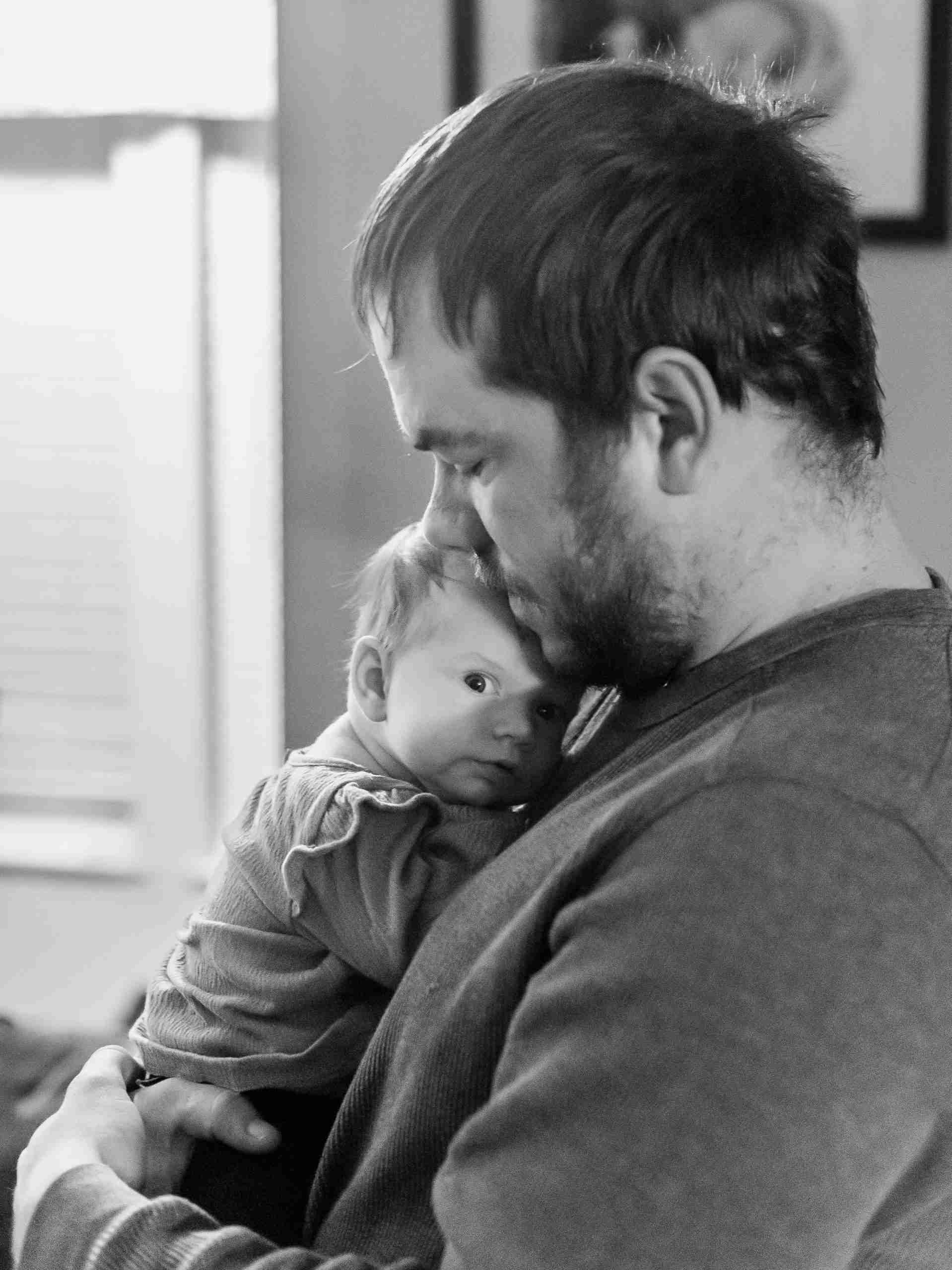 Father holding his baby during a quiet family moment.